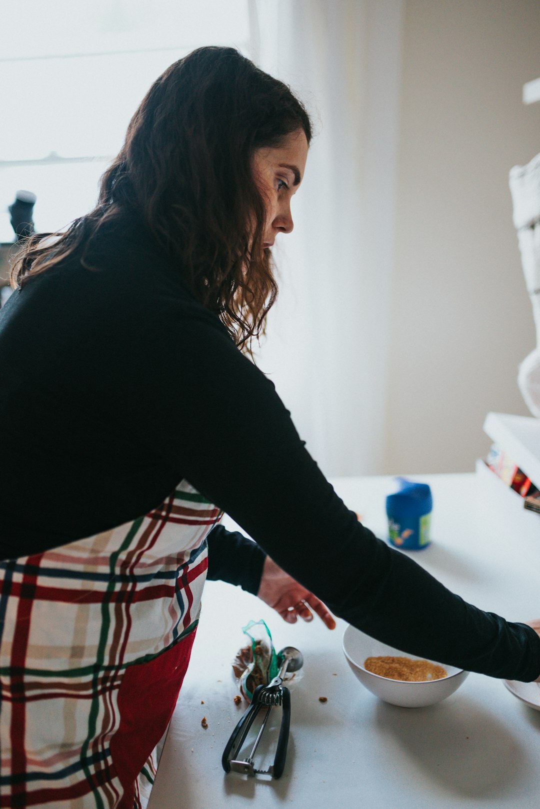 woman in black long sleeve shirt standing in front of sink