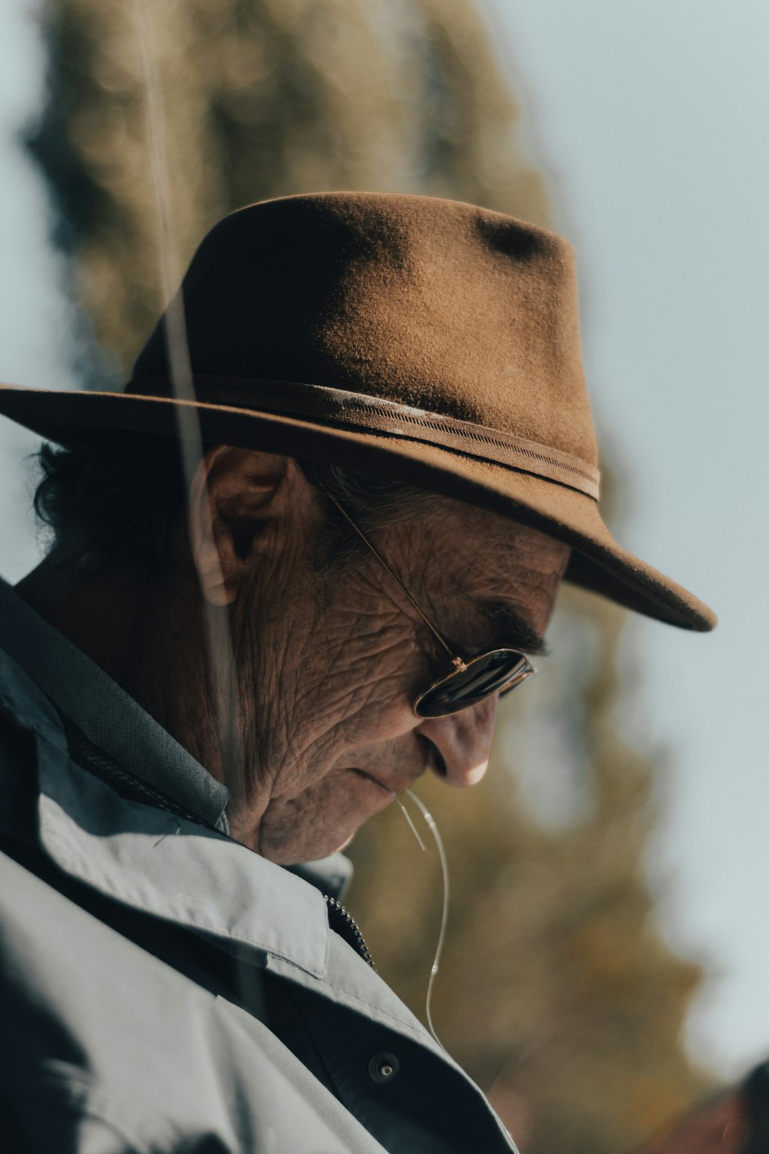 man in white and black hoodie wearing black sunglasses and brown hat