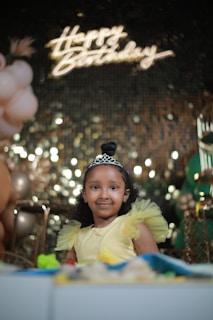 Bella Ileen smiling in her elegant quinceañera dress surrounded by colorful balloons.