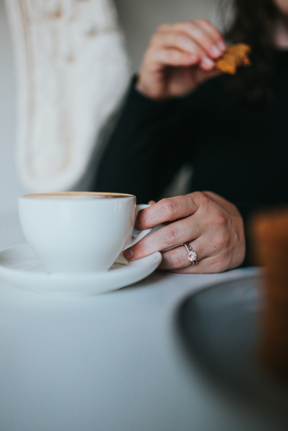 person holding white ceramic teacup