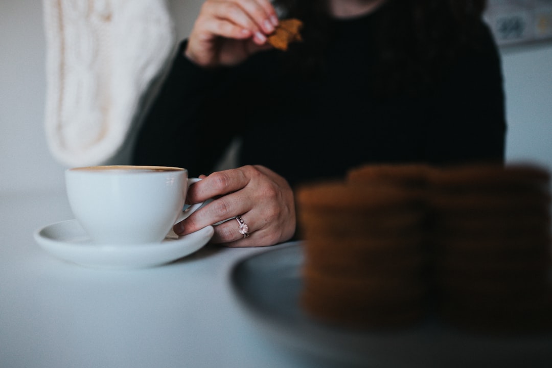 person holding white ceramic teacup