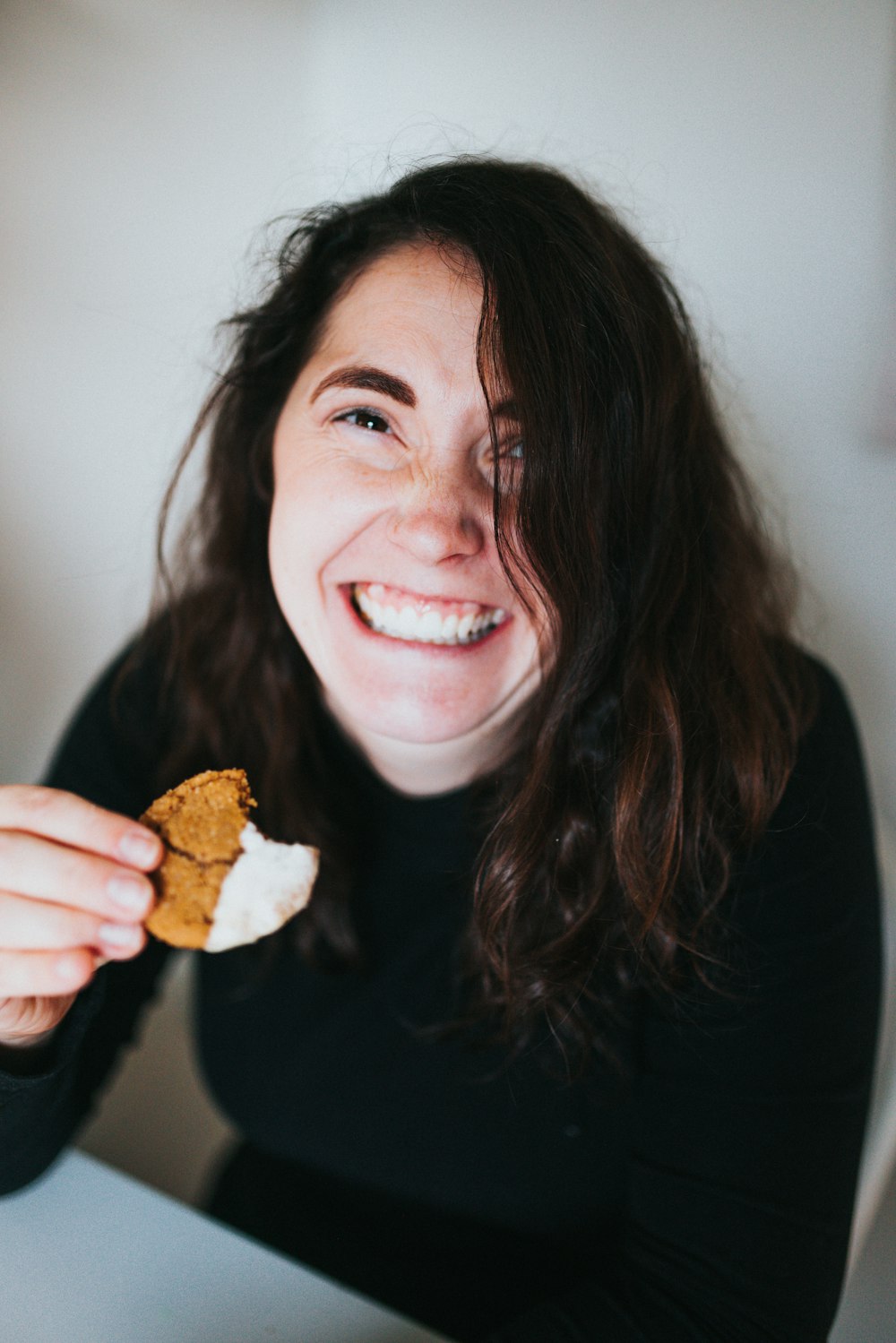 woman in black long sleeve shirt holding bread