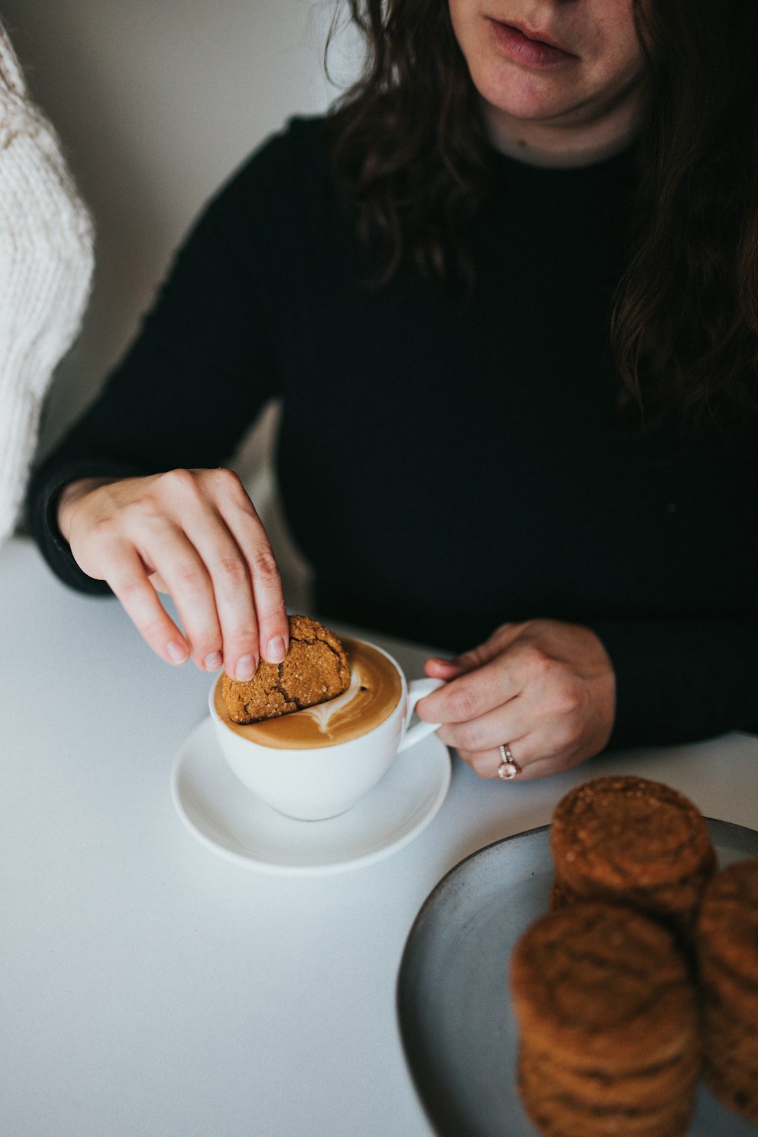 person holding a white ceramic mug with coffee