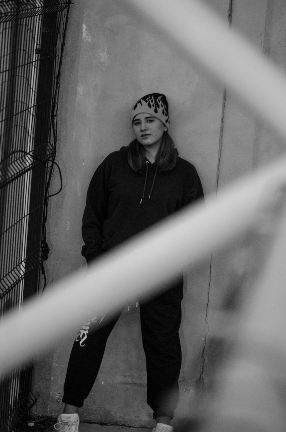 man in black jacket standing beside metal fence