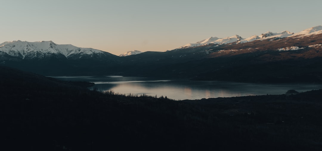 body of water near mountain during daytime