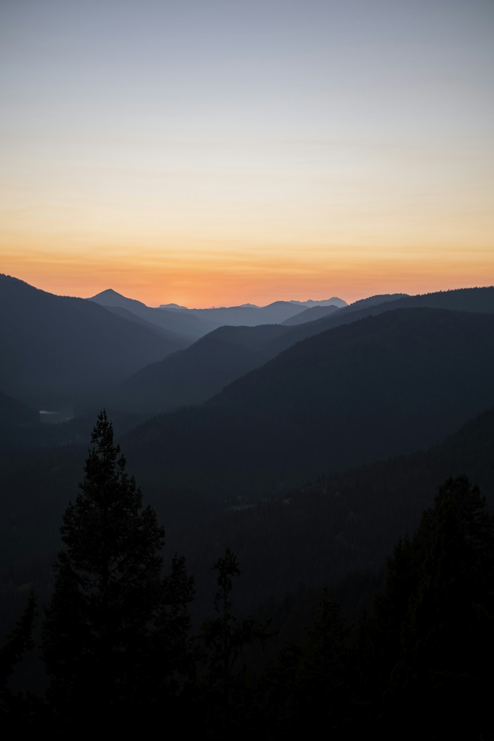 silhouette of trees and mountains during sunset