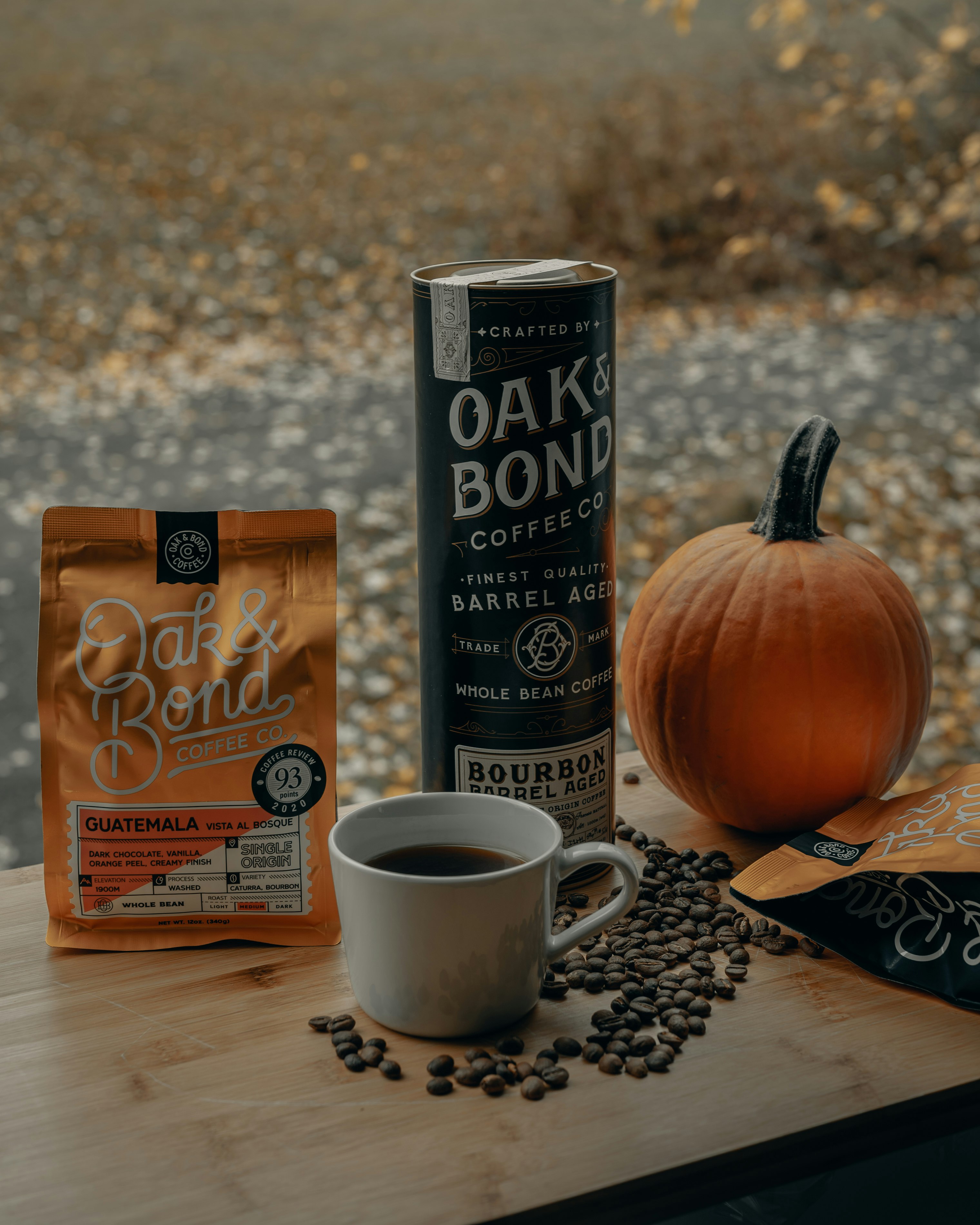 white ceramic mug beside orange pumpkin on brown wooden table