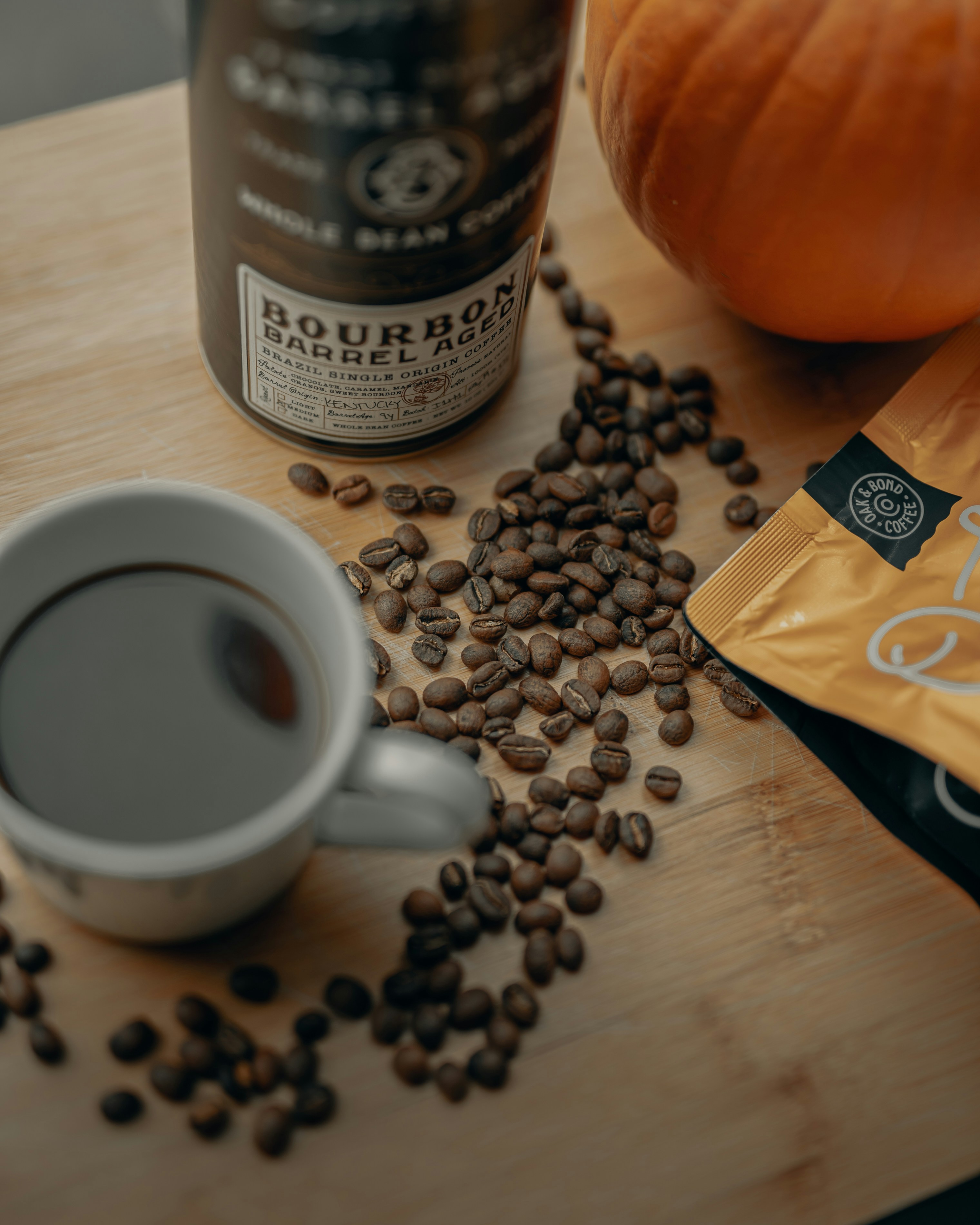 white ceramic mug with coffee beans on brown wooden table