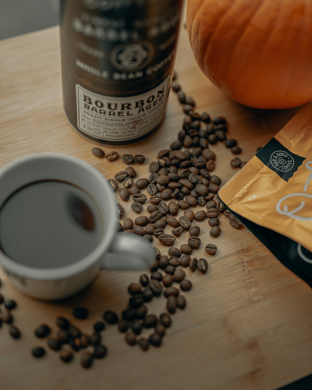 weiße Keramiktasse mit Kaffeebohnen auf braunem Holztisch