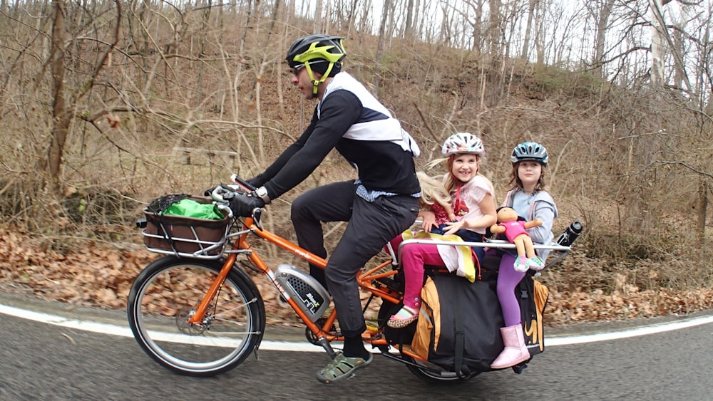 people riding on orange bicycles during daytime