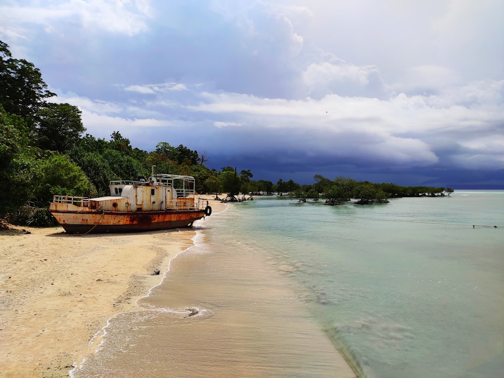 brown boat on sea shore during daytime