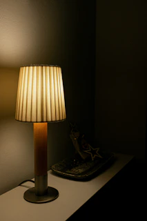 A glowing lamp shaped like a star resting on a bedside table.