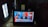 A tablet screen displays a CNN news segment showing results for the 2020 U.S. presidential election with Joe Biden elected president. The broadcast features six separate images of people, including a central anchor and participants in smaller screens. The headline reads 'BREAKING NEWS' and discusses Trump's lack of public acceptance. The setup includes a lit white lamp on the left and a box of crackers sitting behind the tablet.