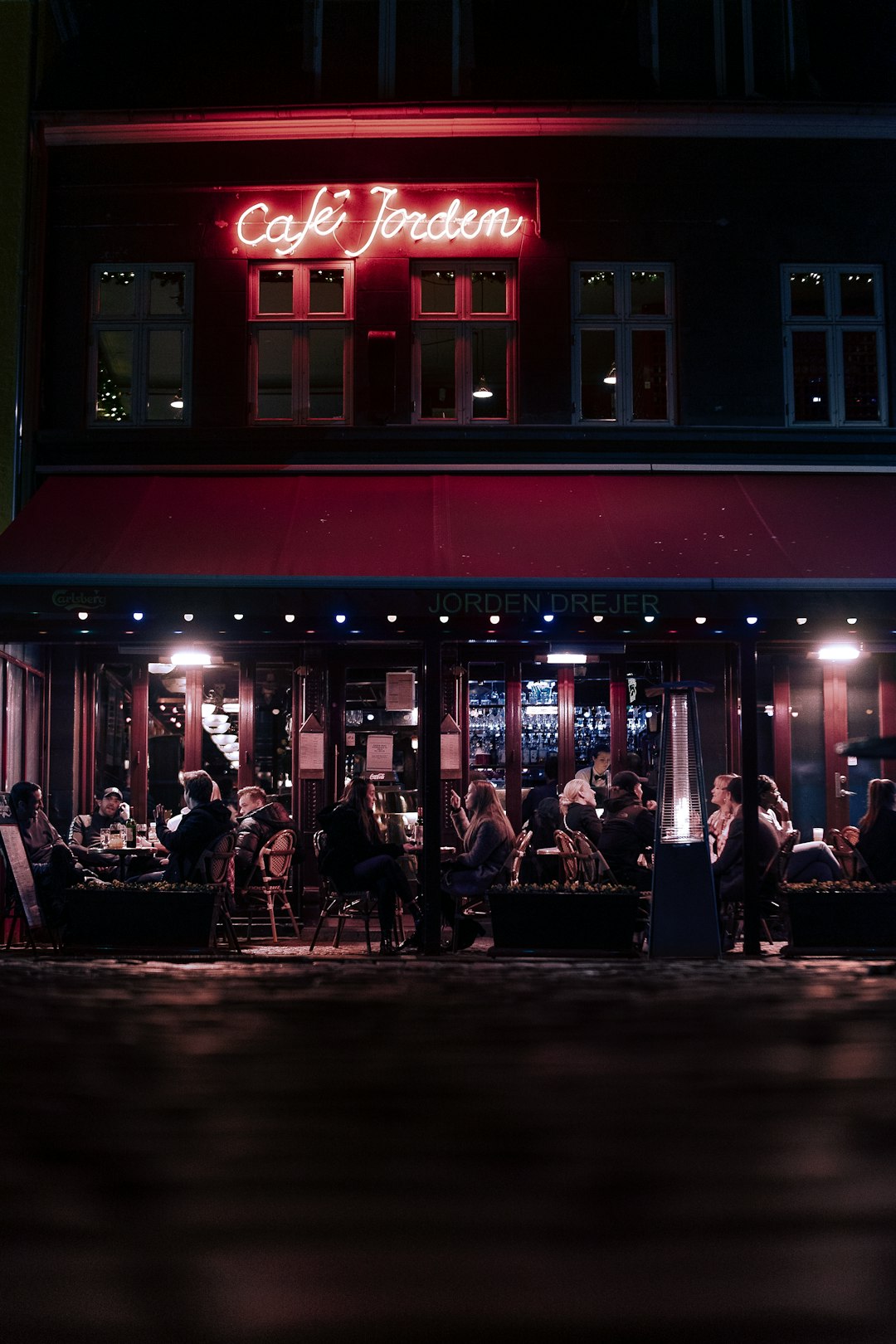 people sitting on chair near red building during night time