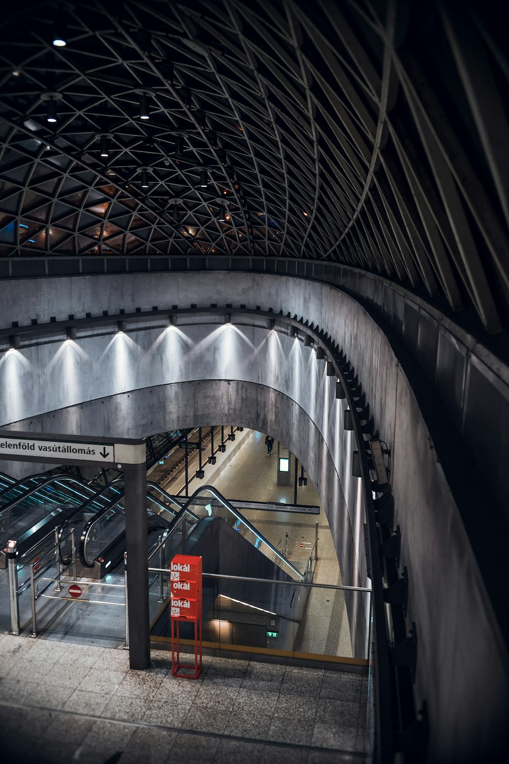 gray metal tunnel with red and yellow signage