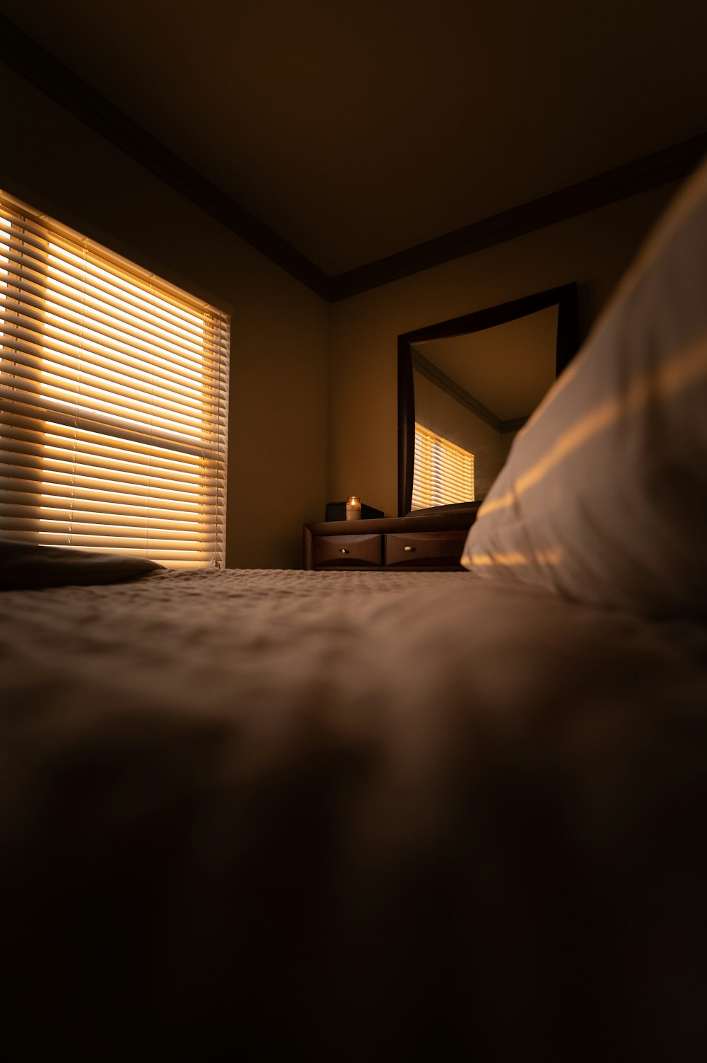 white bed linen near white window blinds