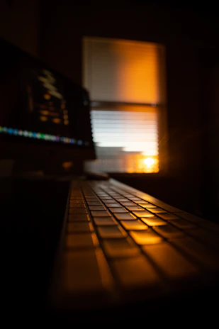 Close-up of hands typing on a keyboard with soft natural light streaming in.