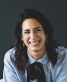 smiling woman in white and black checkered dress shirt