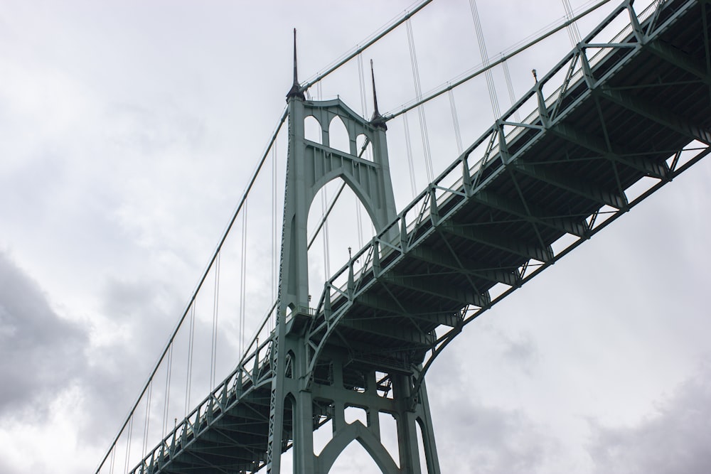 low angle photography of bridge under cloudy sky during daytime