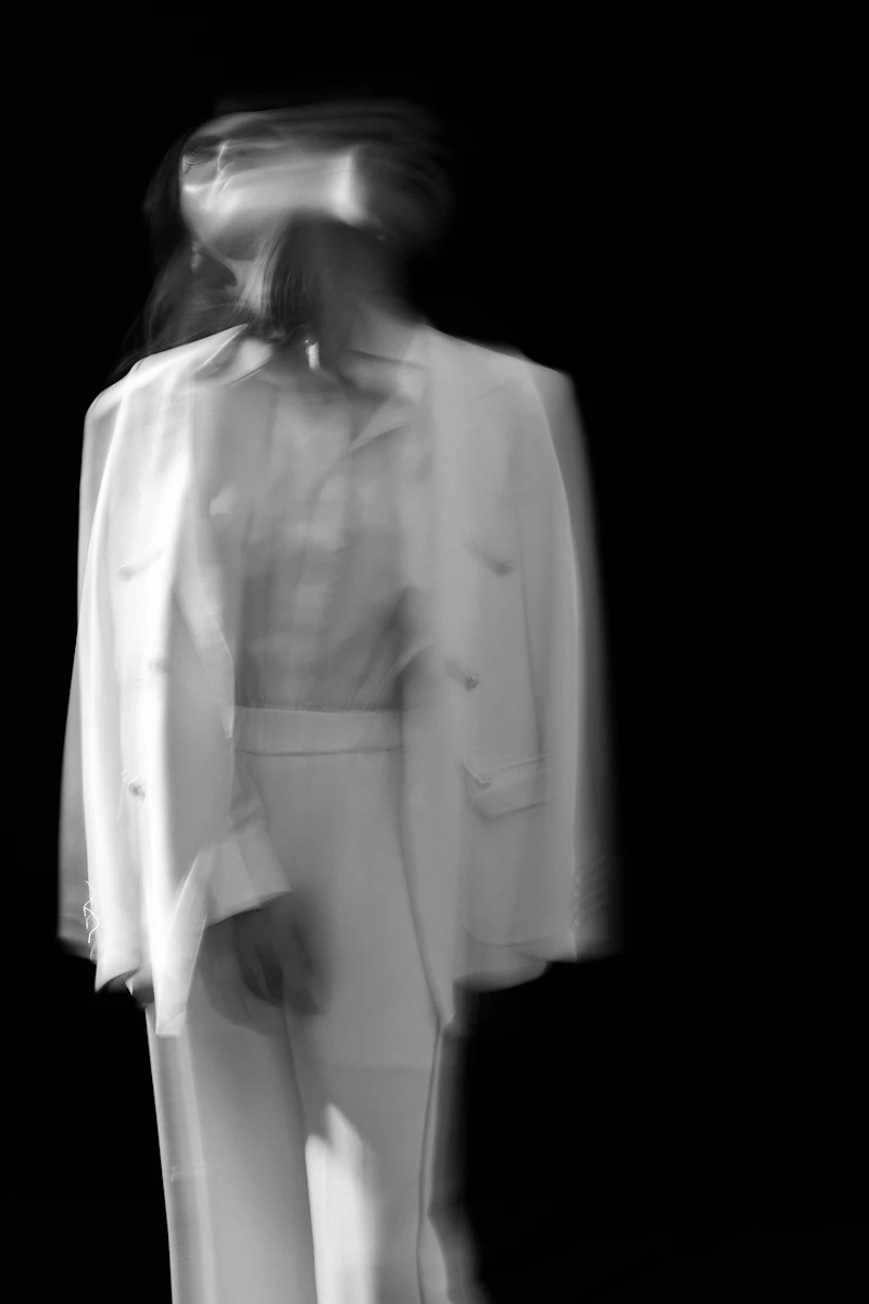 A woman in a white long-sleeve dress, editorial portrait