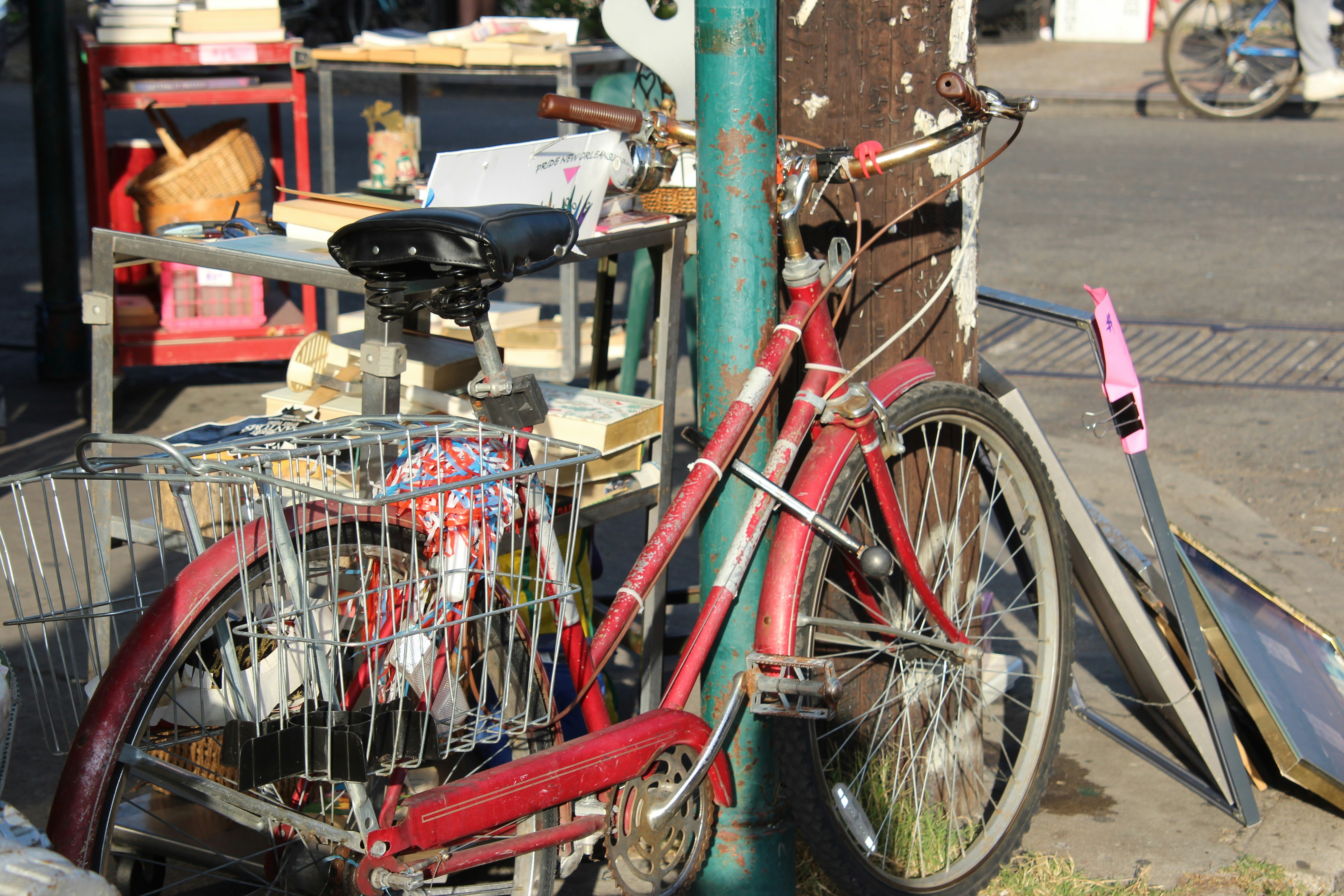 red city bike parked beside green post photo – Free New orleans Image