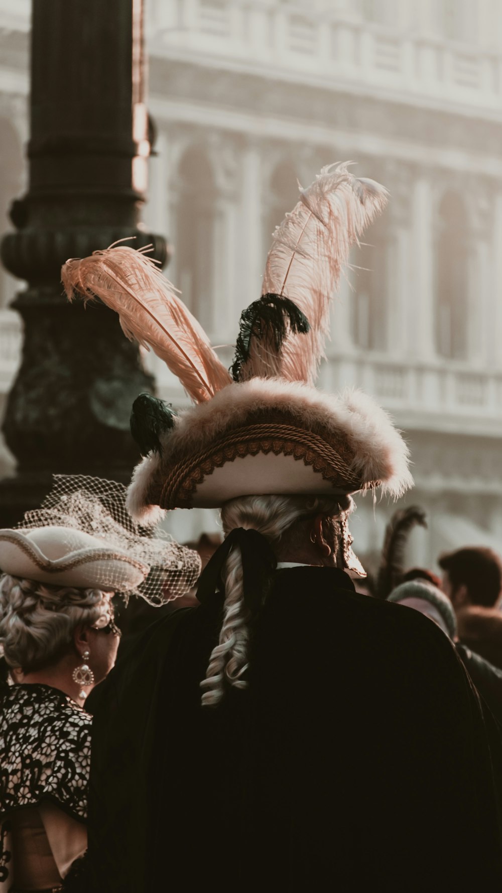 Gente con abrigo negro con alas rosas