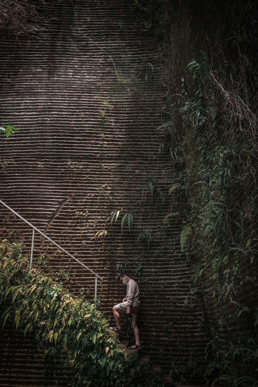 woman in brown jacket and gray pants walking on pathway