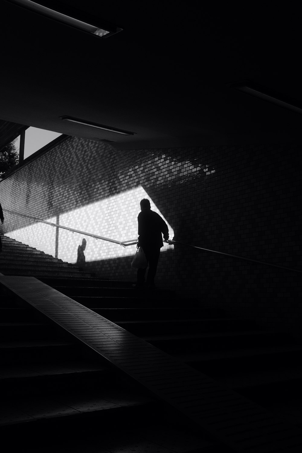 silhouette of person walking on tunnel