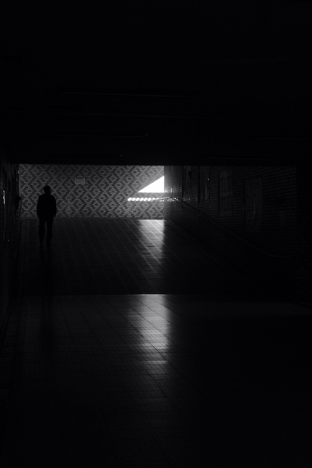 silhouette of person walking on tunnel