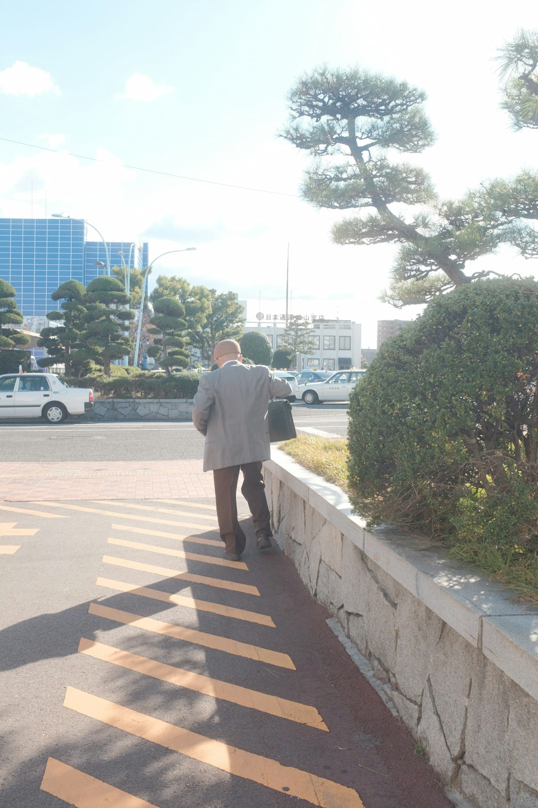 man in white dress shirt standing on brown and white pedestrian lane during daytime