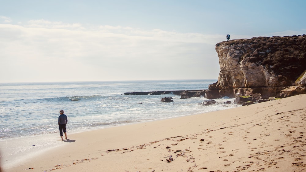 person standing on beach shore during daytime