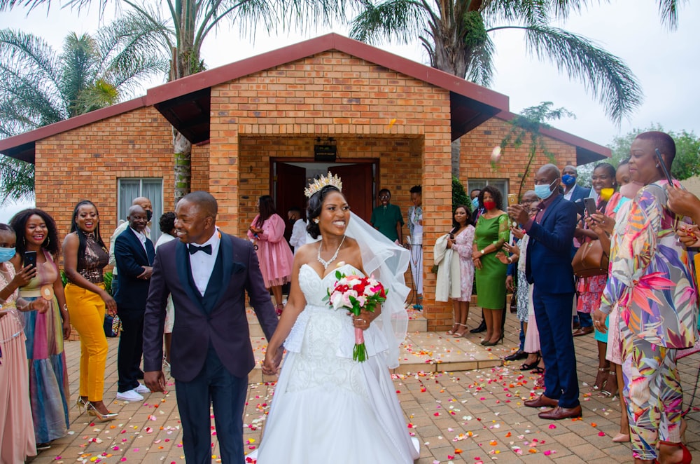 man in black suit jacket and woman in white wedding dress