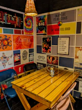 A cozy art gallery corner with vibrant concert posters on the walls and a vintage typewriter on a wooden desk.