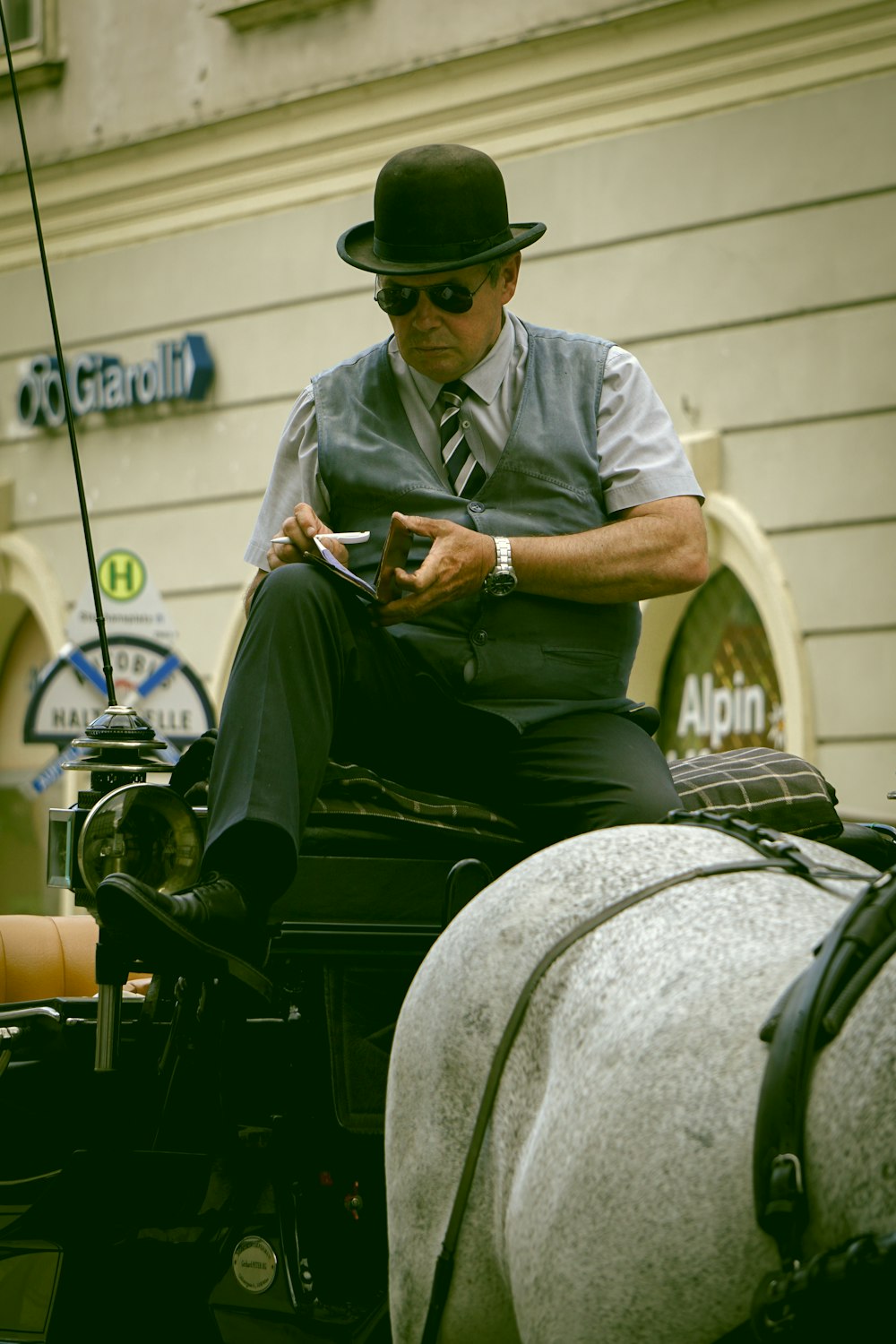 man in gray polo shirt and green hat sitting on black motorcycle during daytime