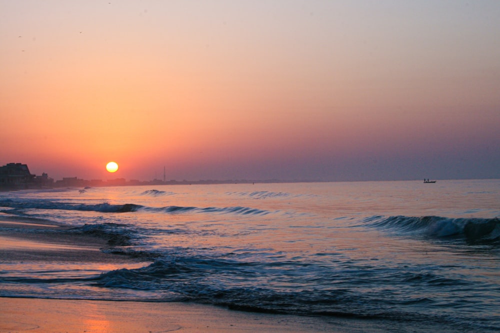 ondas do oceano batendo na costa durante o pôr do sol