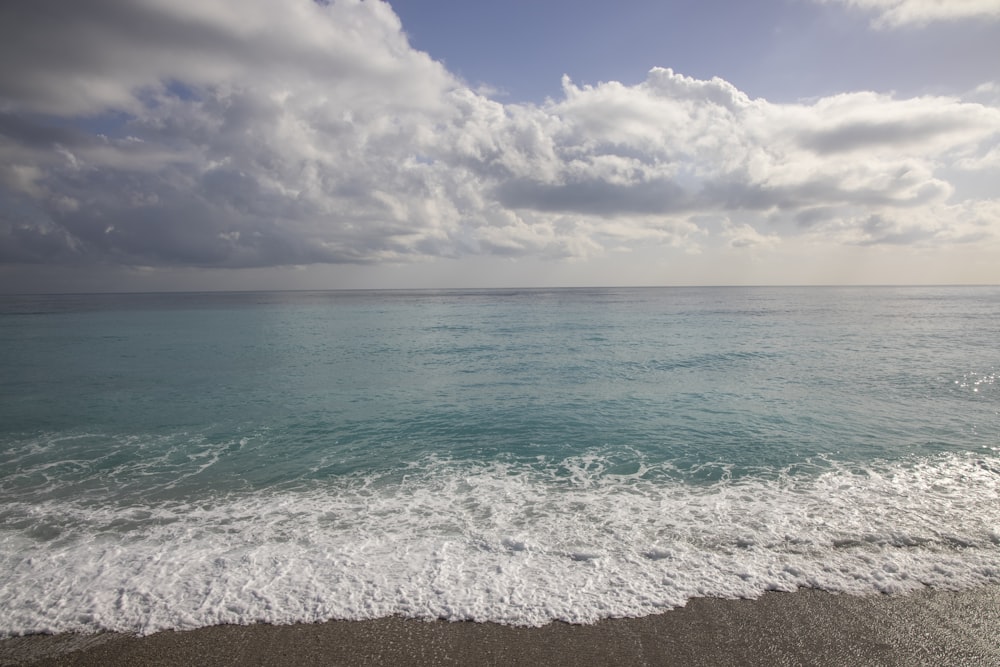 blue sea under blue sky and white clouds during daytime