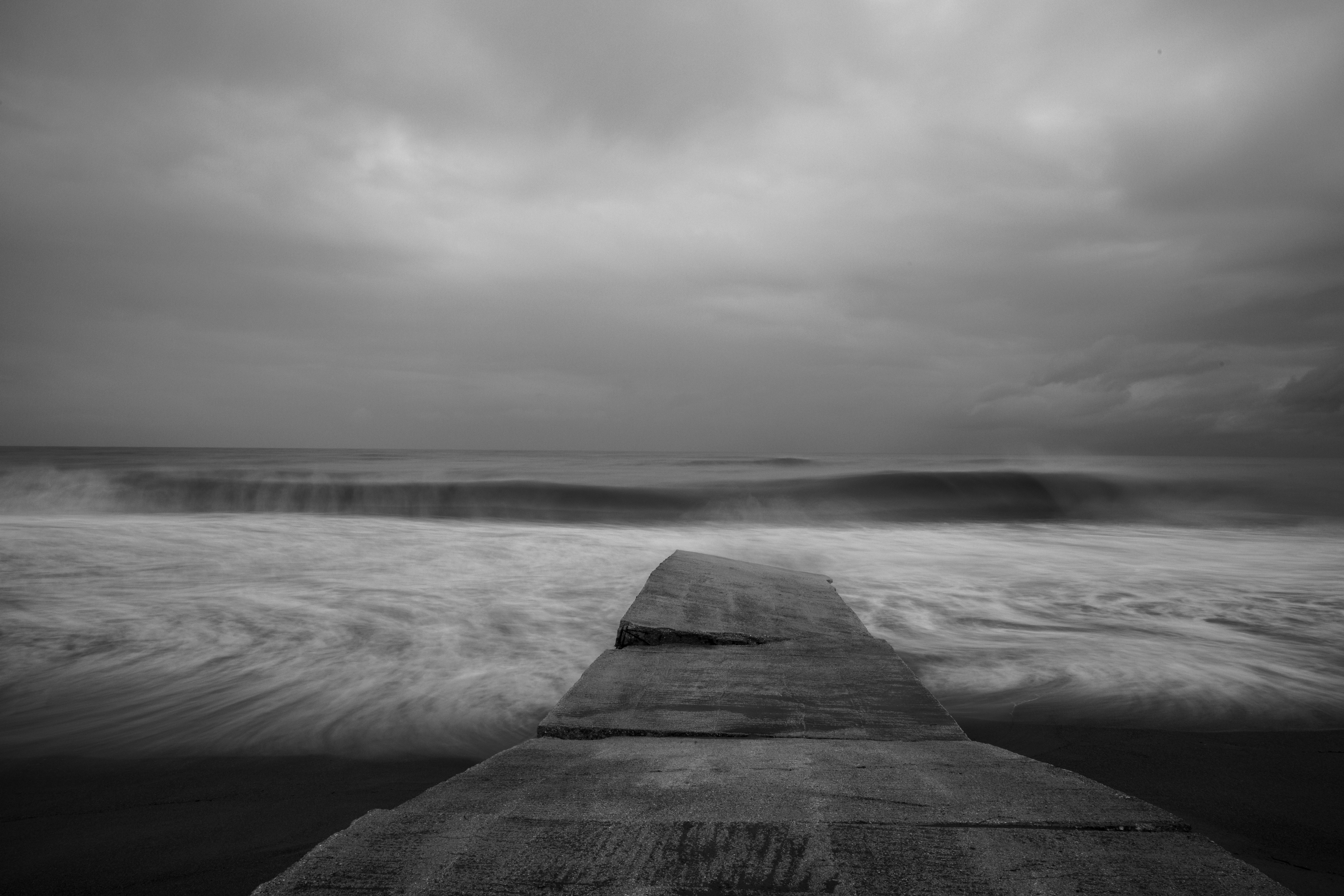 grayscale photo of wooden dock on body of water