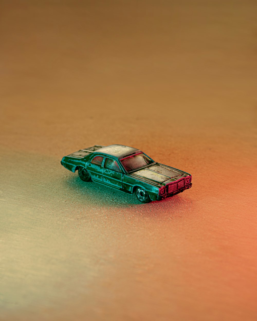 teal car scale model on brown wooden table