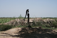A technician installing a sturdy water pump on an agricultural field under a bright sky.