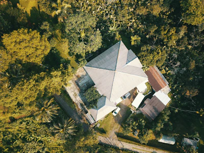 An aerial view of a green building surrounded by nature and urban elements.