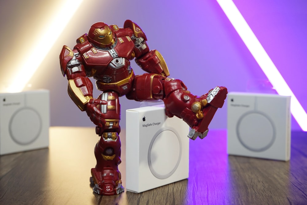 red robot action figure on brown wooden table