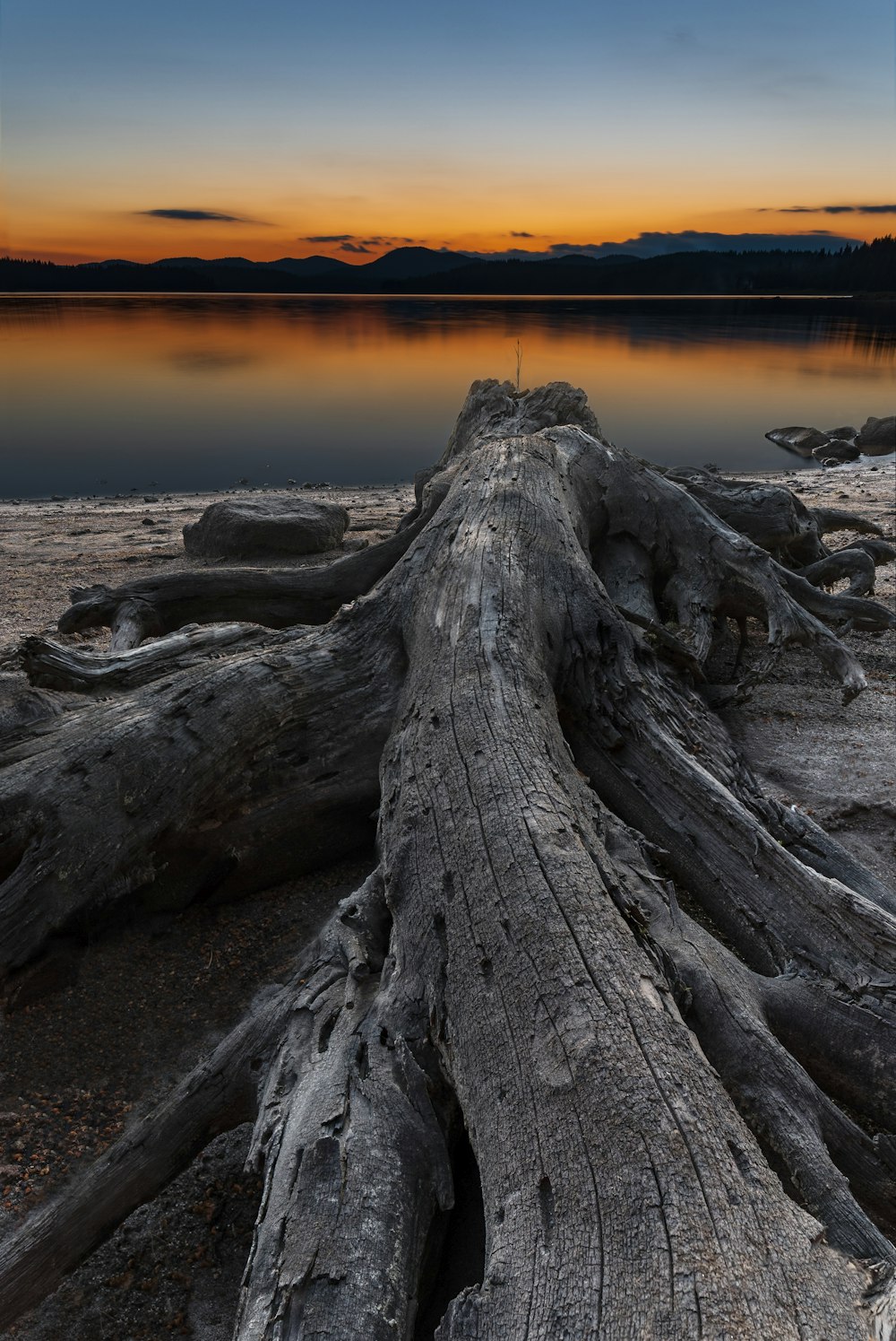 black and gray rock formation near body of water during sunset