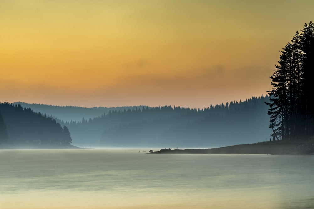 body of water near mountain during daytime