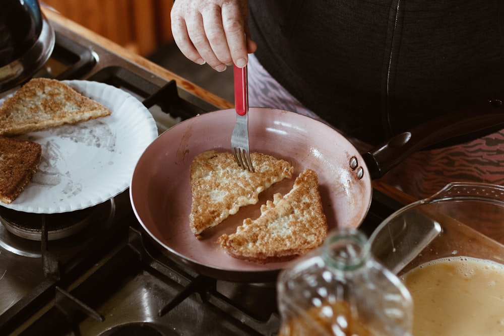 person holding stainless steel bowl with brown rice