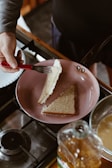 Hands carefully dipping bread slices into egg mixture in a cozy kitchen.