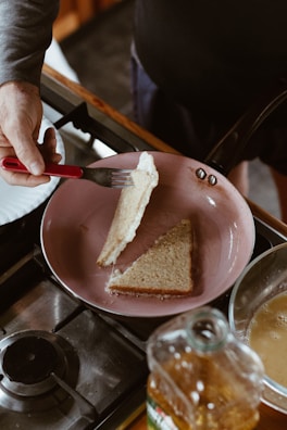 Hands carefully dipping bread slices into egg mixture in a cozy kitchen.