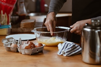 person holding clear glass bowl with eggs