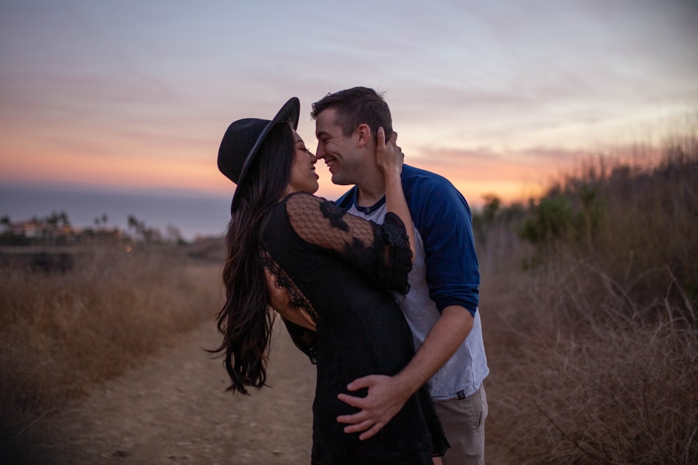 a man and a woman kissing in a field