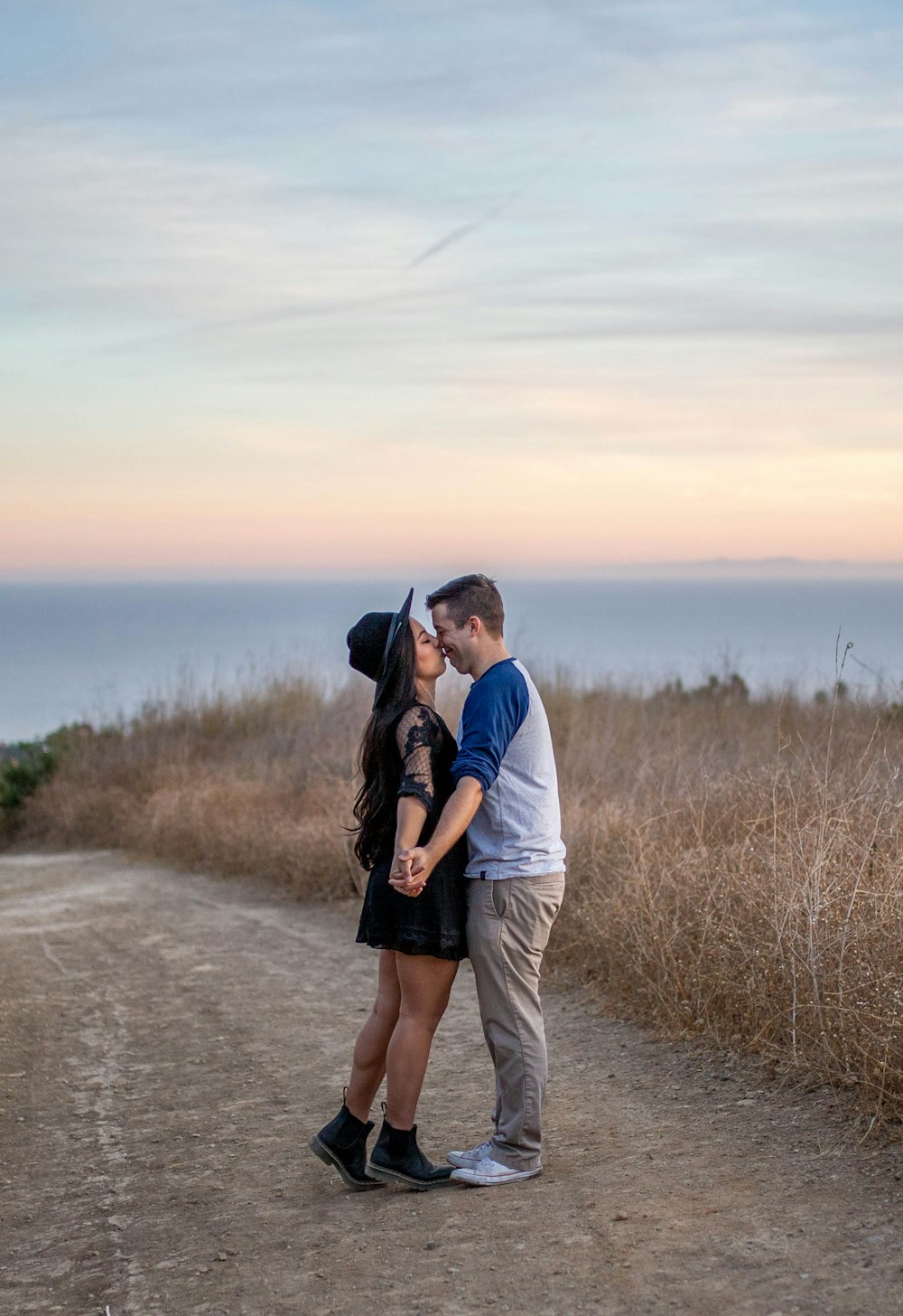 man and woman kissing on road during daytime