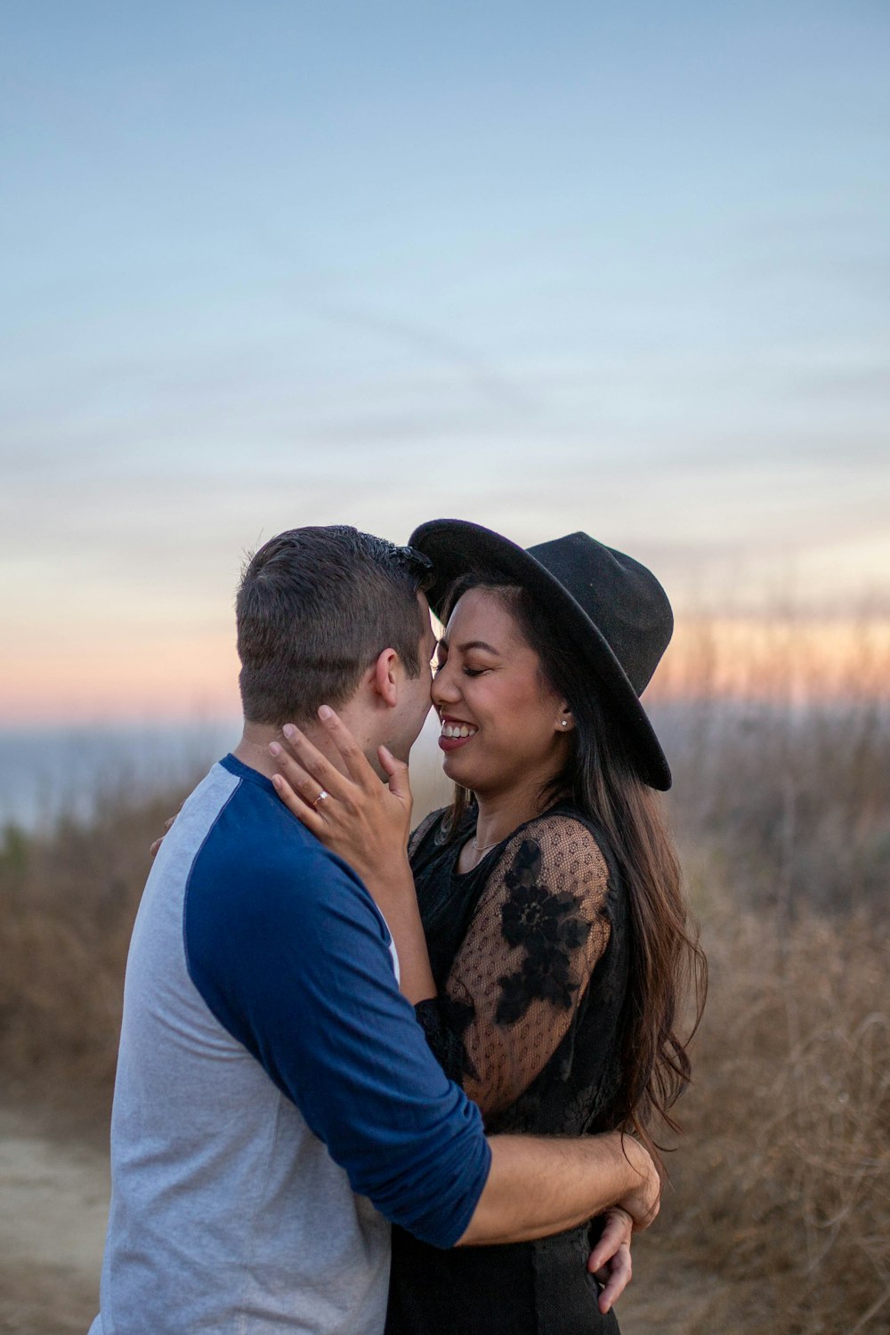 man in blue shirt kissing woman in brown and black floral shirt